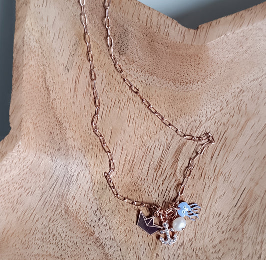 Collana portamifortuna con  barchetta di carta, medusa in smalto lilla, ancora in zirconi, perla